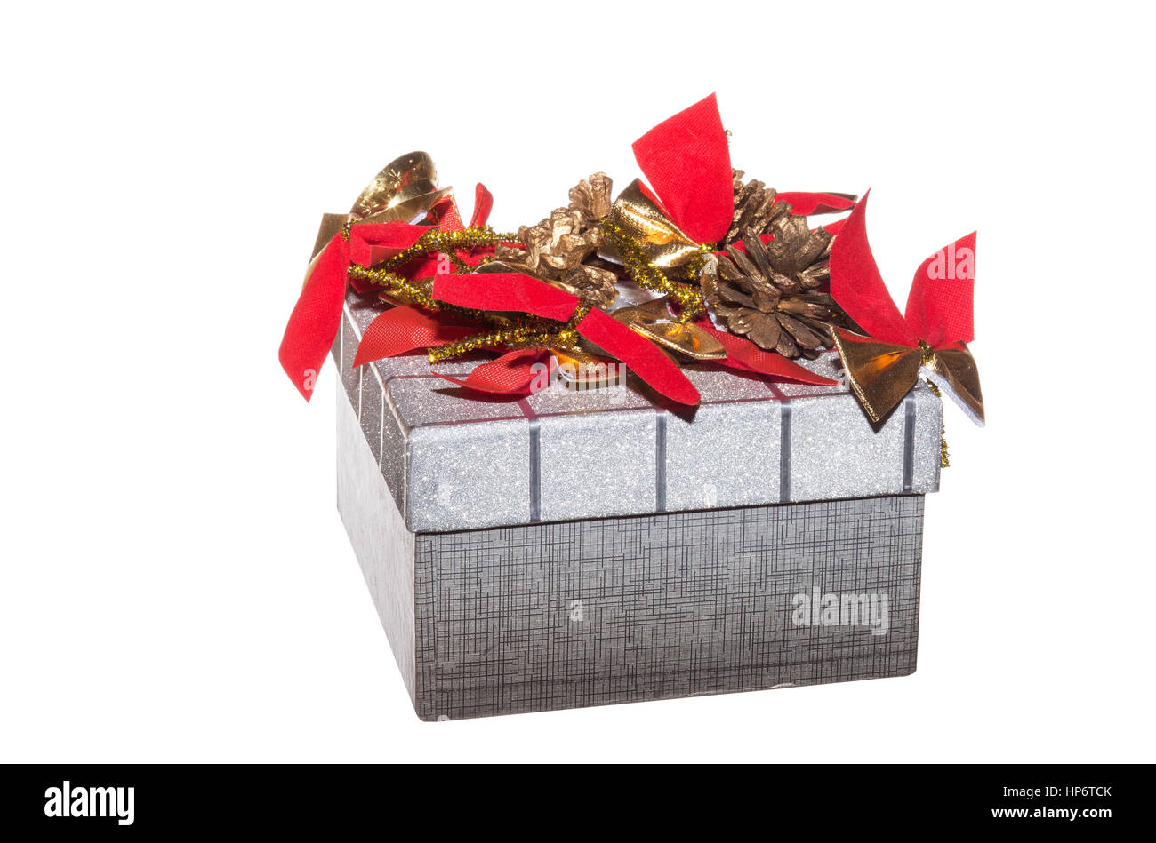 Decorate confezione regalo isolato su sfondo bianco. Confezione regalo decorato con archi rossi e pigne. Foto Stock