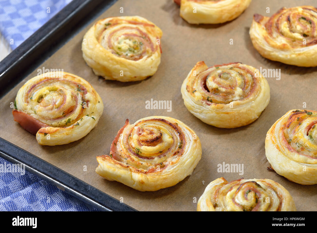 Cotta ricca di pasta sfoglia panini con prosciutto, crema di formaggio parmigiano e erbe su una piastra Foto Stock