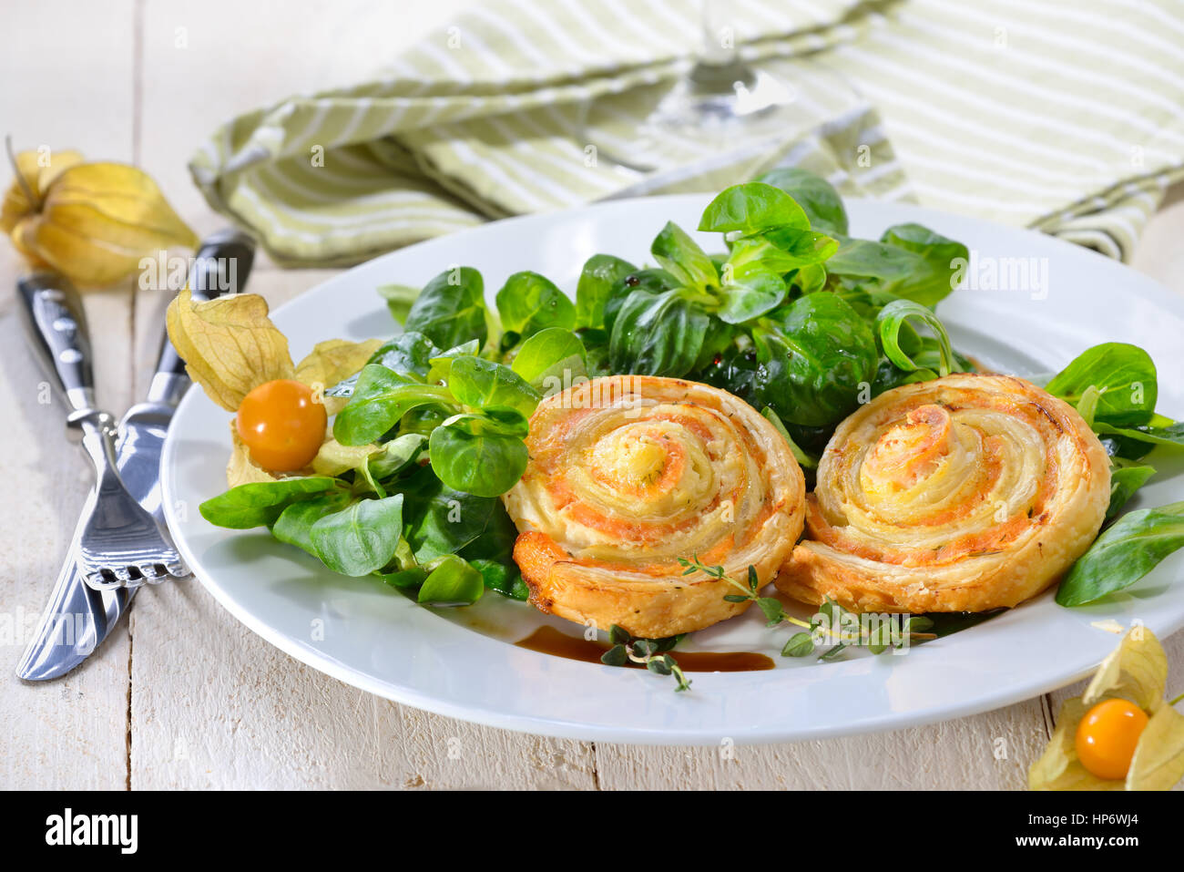 Cotta sostanziosa pasta sfoglia spuntini con salmone affumicato e crema di formaggio ed erbe fresche sulla lattuga agnelli Foto Stock