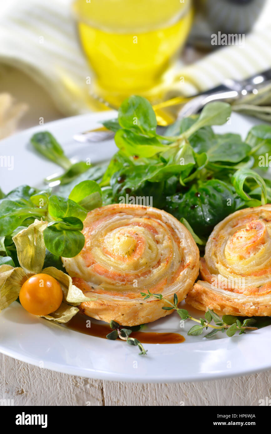 Cotta sostanziosa pasta sfoglia spuntini con salmone affumicato e crema di formaggio ed erbe fresche sulla lattuga agnelli Foto Stock