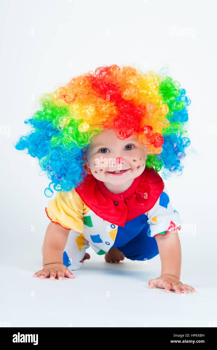 Bambino clown con un naso rosso multicolore in parrucca con sfere Foto  stock - Alamy