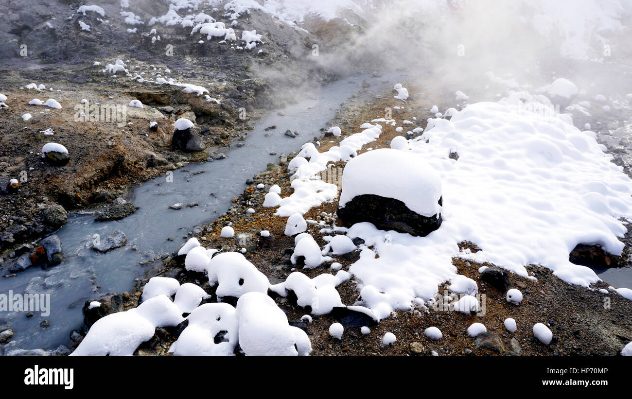 Primo piano della pietra e del flusso nella nebbia Noboribetsu Onsen neve invernale del parco nazionale di Jigokudani, Hokkaido, Giappone Foto Stock