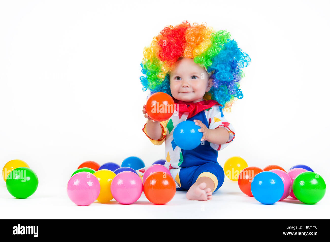 Bambino clown con un naso rosso multicolore in parrucca con sfere Foto Stock