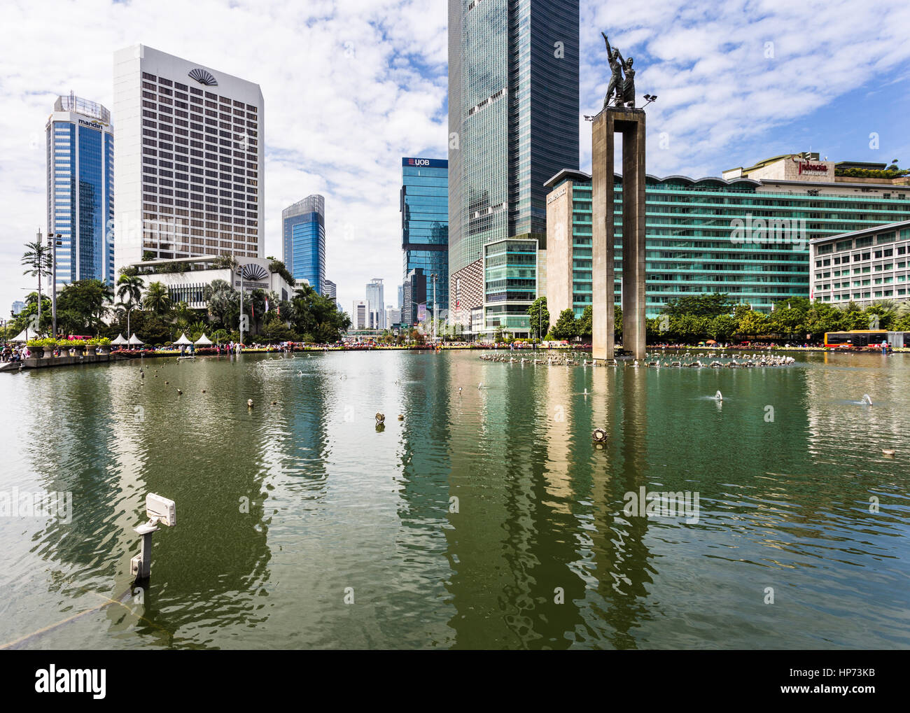 JAKARTA, Indonesia - 25 settembre 2016: alti edifici adibiti ad uffici e hotel di lusso riflettono nell'acqua della fontana dei Selamat Datang monumento mi Foto Stock