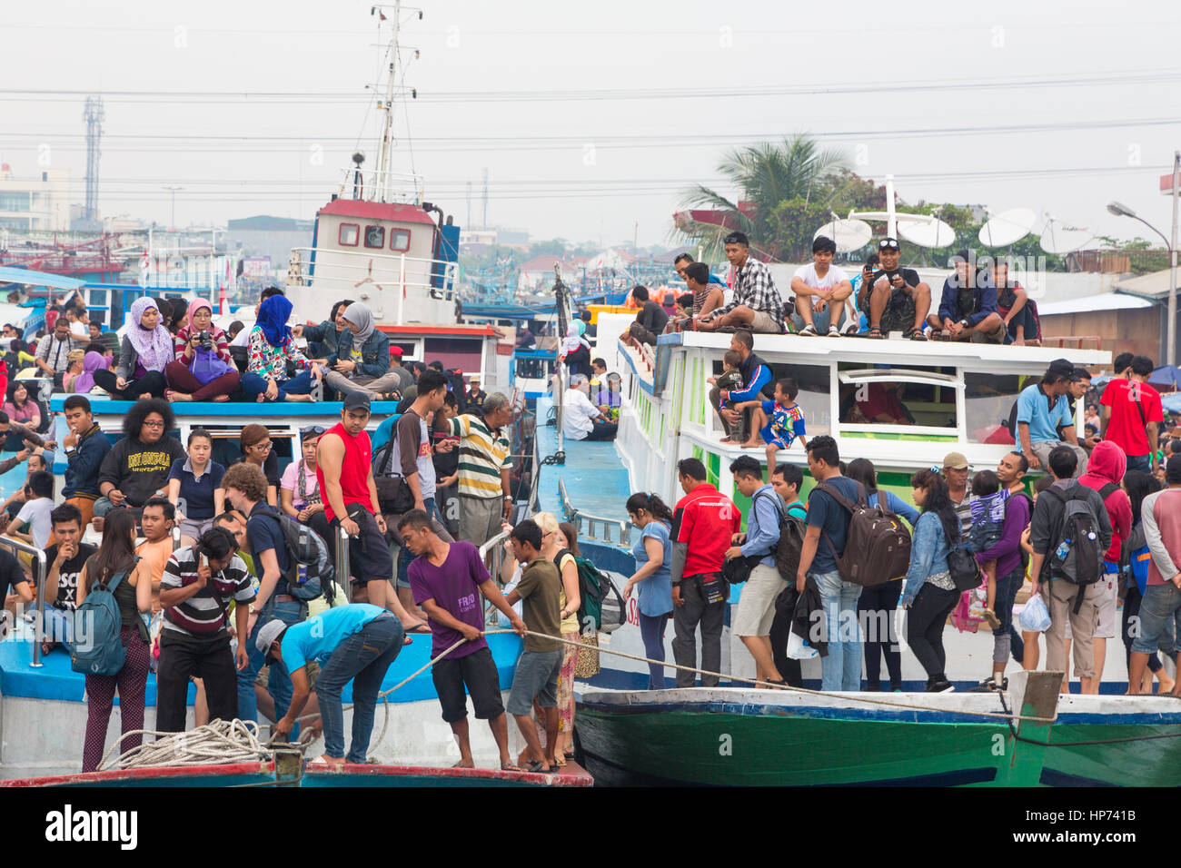 Jakarta, Indonesia - 7 Settembre 2013: persone squeeze dall' sul vecchio legno barche traghetto nel porto di Jakarta voce ai mille isola Jak Foto Stock