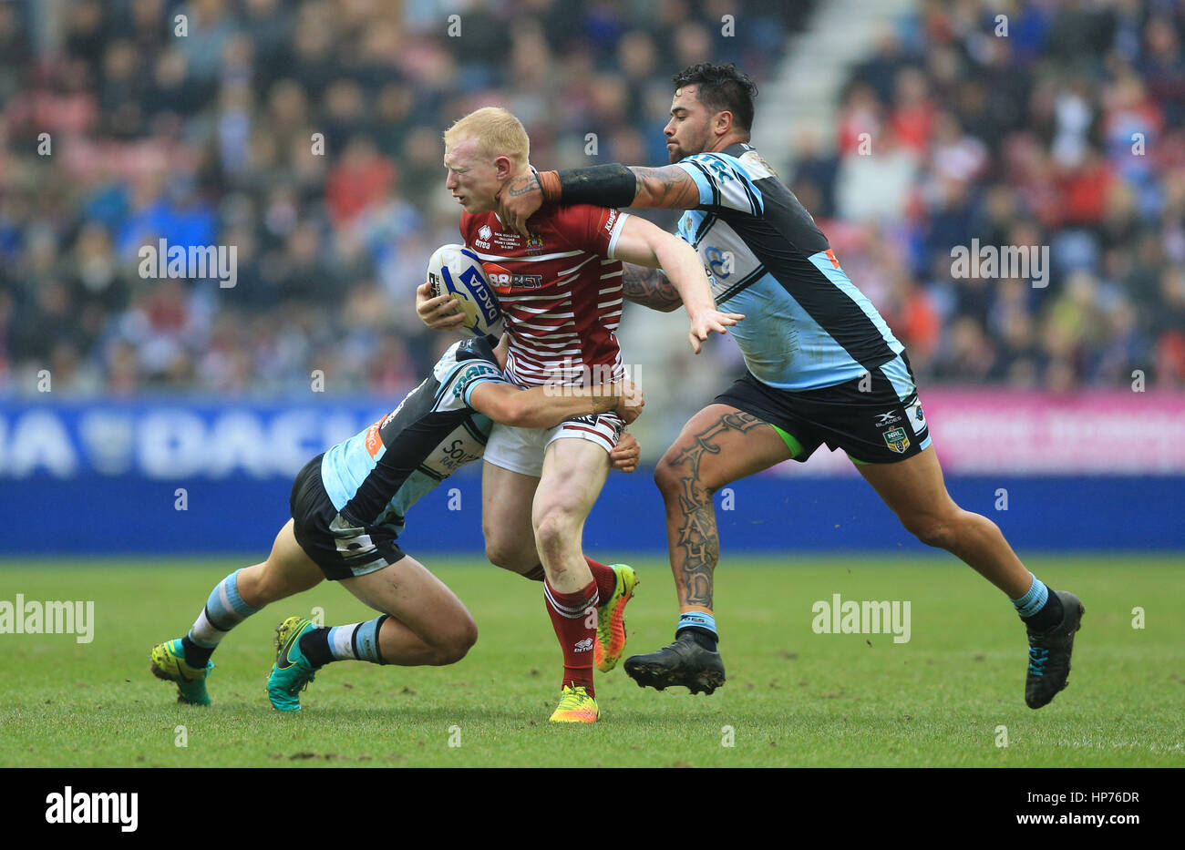 Il Wigan Warriors' Liam Farrell è affrontato con gli squali Cronulla-Sutherland' Jayden Brailey (sinistra) durante il 2017 Dacia World Club serie corrispondono al DW Stadium, Wigan. Foto Stock