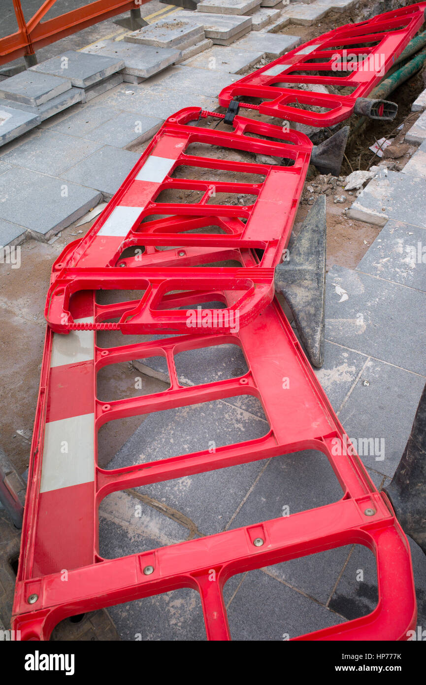 Le barriere in plastica per separare lavori stradali da traffico e pedoni giacente sul terreno, Liverpool Regno Unito Foto Stock