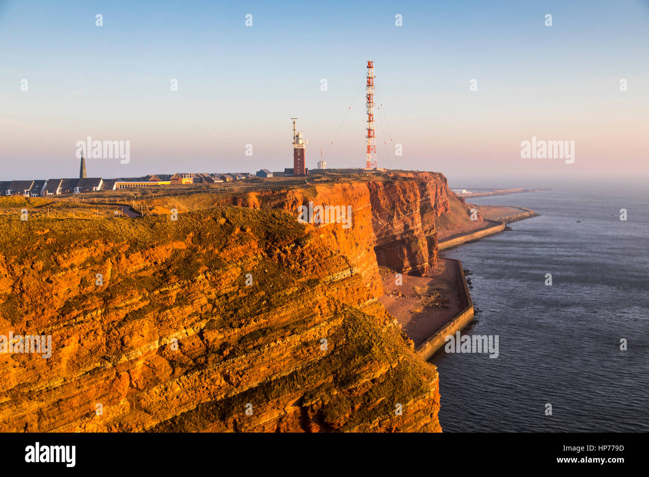 Il rosso costa ripida linea di Helgoland, un isola tedesca nel Mare del Nord, Faro e radio-sistema di relè il montante dell'antenna, Foto Stock