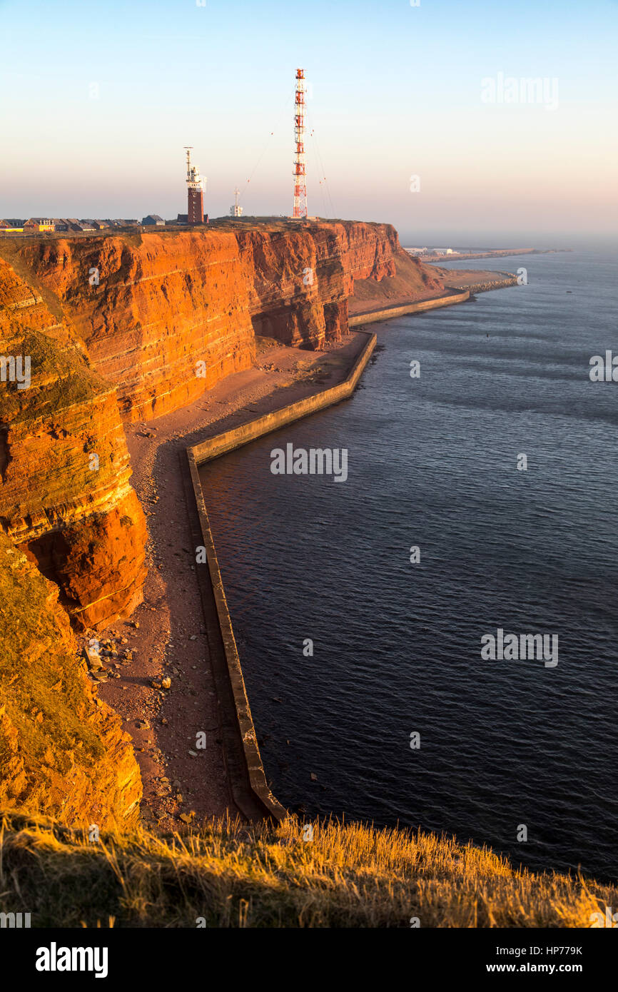 Il rosso costa ripida linea di Helgoland, un isola tedesca nel Mare del Nord, Faro e radio-sistema di relè il montante dell'antenna, Foto Stock