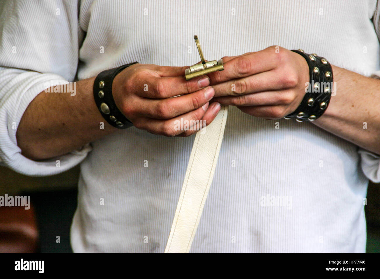 Giovane maschio artigiano realizzazione artigianale di cinture in pelle Foto Stock