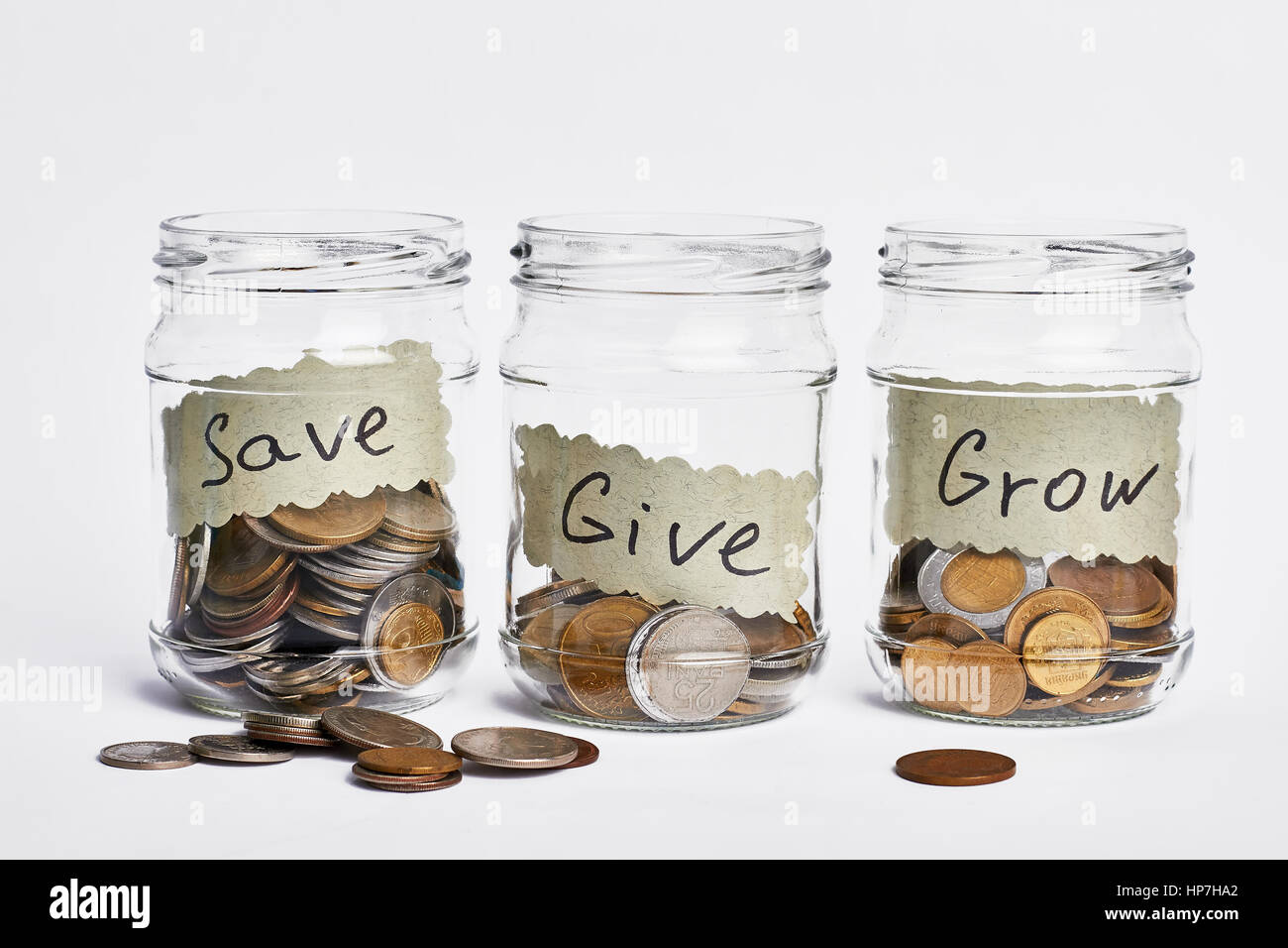 Giare la metà piena di monete. Il concetto di distribuzione del reddito. Foto Stock