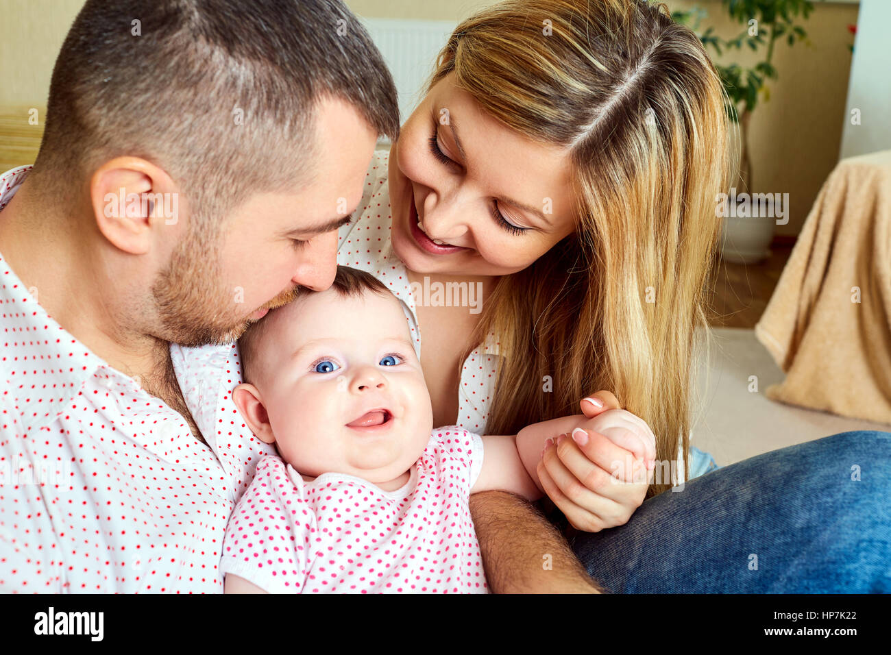 Una famiglia felice. Mamma e papà con il bambino in camera Foto Stock