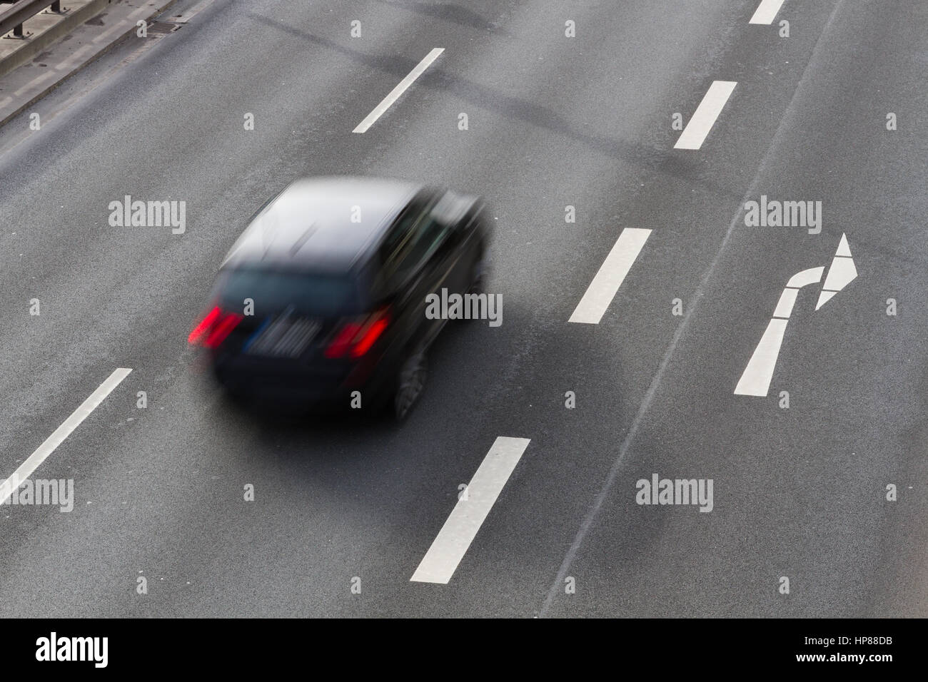 Un auto guidando lungo una strada a doppia carreggiata con una svolta a destra corsia Foto Stock