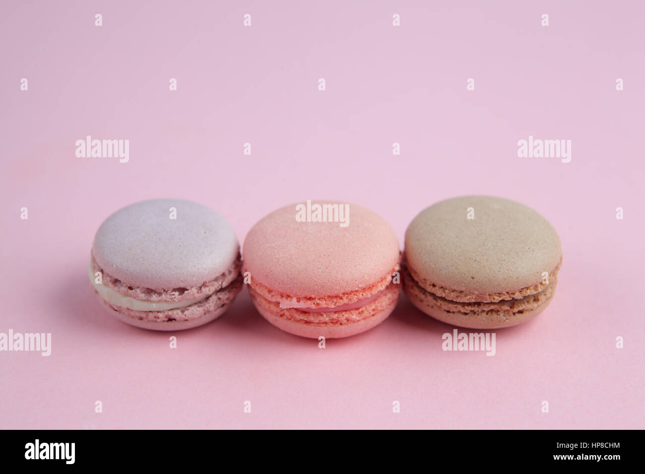 Francese macarons pastello su uno sfondo rosa Foto Stock