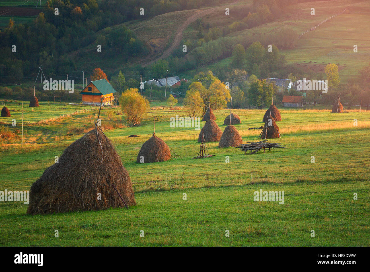 Bellissimo paesaggio rurale. Estate mattina di sole nel villaggio. Sun si illumina di verde sulle colline di montagna. Foto Stock