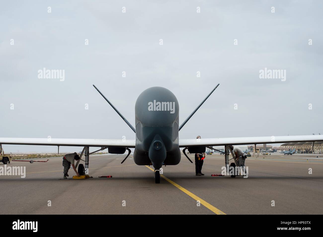 Abu Dhabi, negli Emirati Arabi Uniti. Xx Febbraio 2017. Un U.S. Air Force equipaggio di manutenzione assicura un RQ-4 Global Hawk UAV dopo lo sbarco ad Al Dhafra Air Base da una sortita a sostegno di funzionamento inerenti risolvere battendo contro lo Stato islamico Febbraio 20, 2017 ad Abu Dhabi, negli Emirati Arabi Uniti. Credito: Planetpix/Alamy Live News Foto Stock