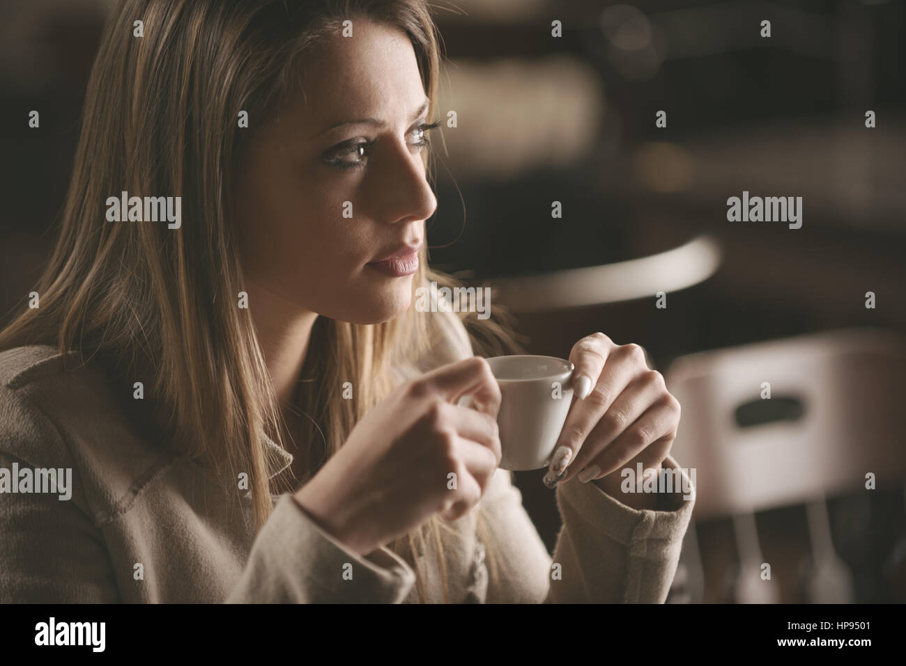 Bella donna avente una tazza di caffè presso il bar Foto Stock