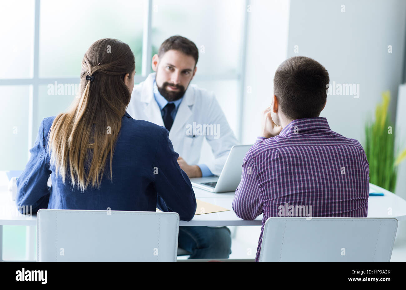 Coppia giovane presso l'ufficio del medico durante una visita e una consulenza medica e il concetto di consultazione Foto Stock