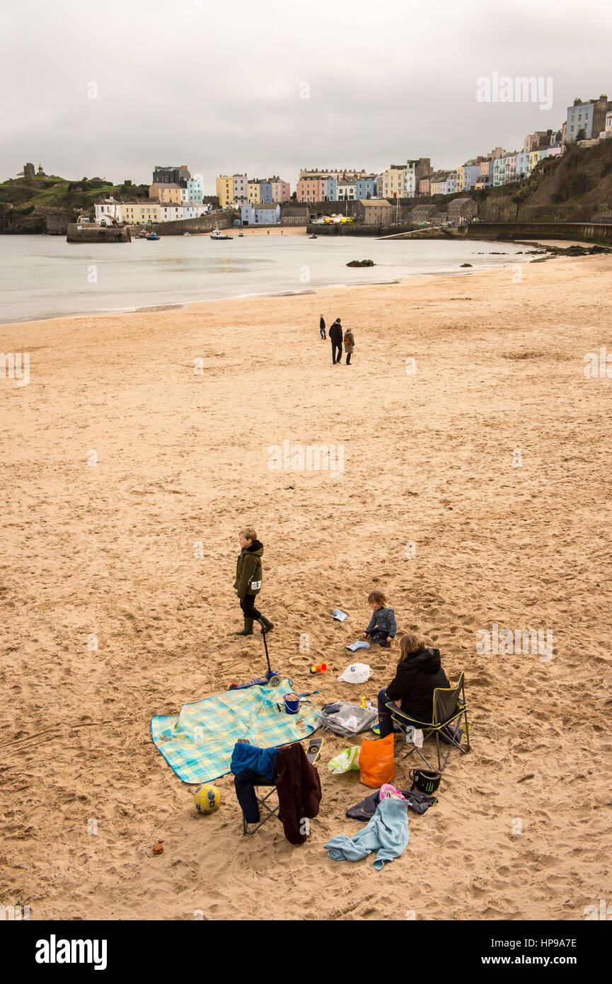 Le persone godono di un picnic sulla spiaggia di Tenby, West Wales, dove le temperature miti hanno attirato visitatori della zona come unseasonably caldo prende in mano in tutto il Regno Unito. Foto Stock