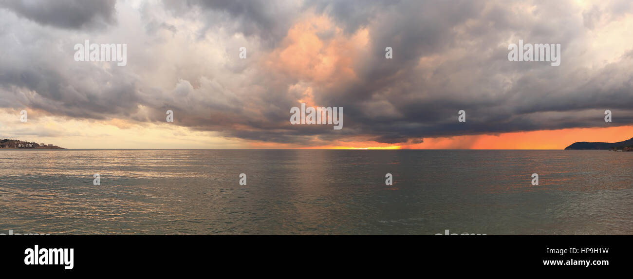 La sera si accendono di luce solare acqua di mare attraverso le nuvole Foto Stock