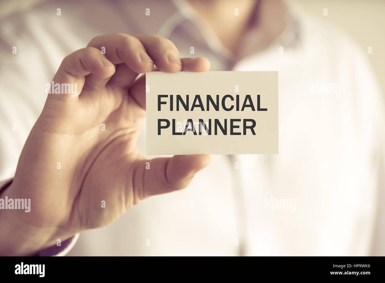 Primo piano su imprenditore tenendo una scheda con il testo pianificatore finanziario, business Concetto di immagine con soft focus background e tono vintage Foto Stock Primo piano su imprenditore tenendo una scheda con il testo pianificatore finanziario, business Concetto di immagine con soft focus background e tono vintage Foto Stock