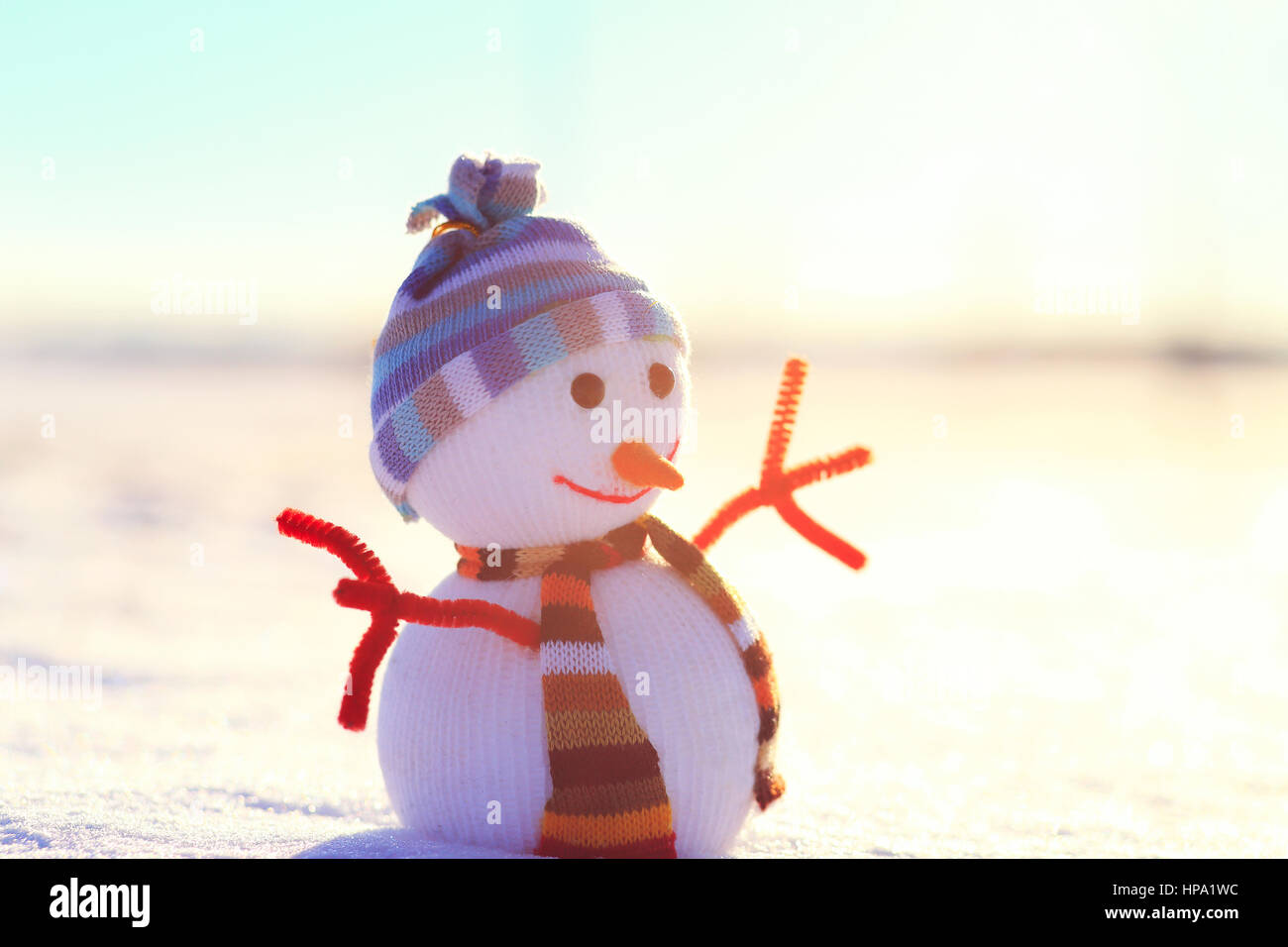 Bianco Natale pupazzo di neve sulla neve. In inverno il sole splende sul pupazzo di neve. Pupazzo di neve con hat nella soleggiata mattina di natale. Colorato sfondo d'inverno. Foto Stock