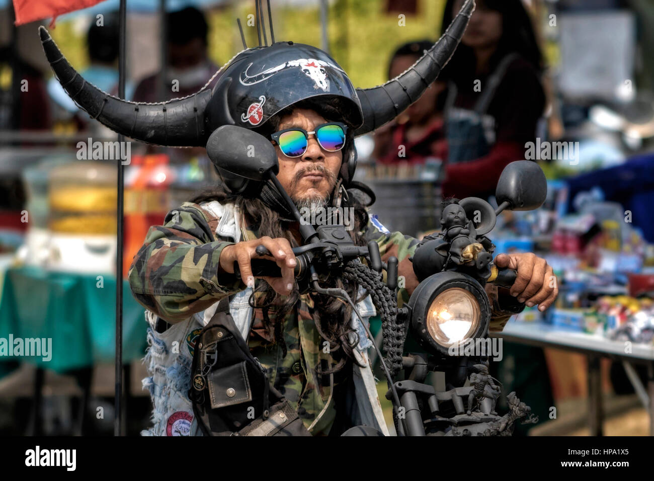 Biker in un festival motociclistico con un casco di sicurezza molto insolito e personalizzato. Thailandia persone, Sud-Est asiatico Foto Stock
