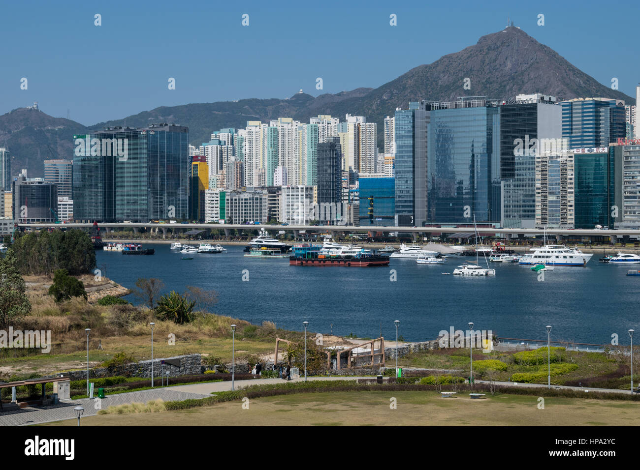 Skyline di Kwun Tong distretto (Hong Kong) affacciato su barche in un typhoon shelter, con una montagna in background Foto Stock