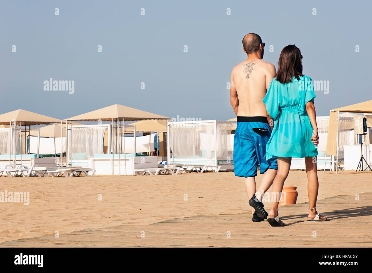 Coppia giovane tenendo le mani e camminando sulla spiaggia Foto Stock