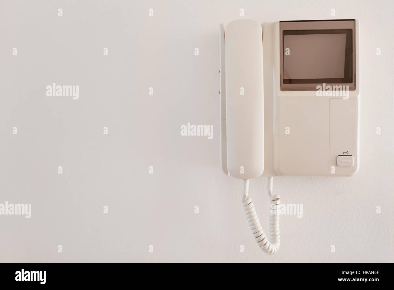 Sistema di citofono con segnale porta appesa sul muro bianco Foto Stock