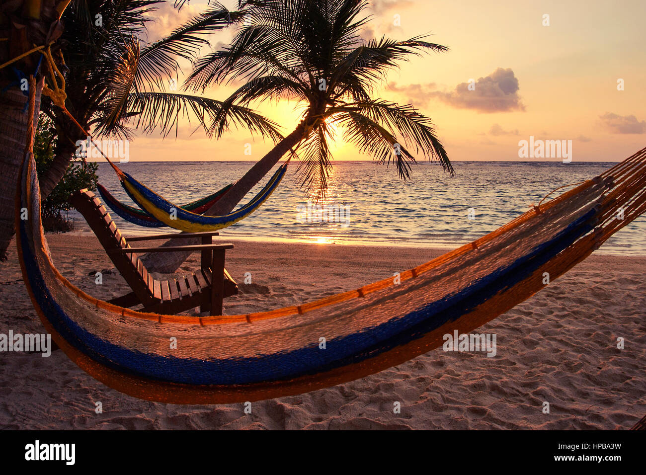 Alba sul sud acqua Caye Belize con amaca e vista sull'oceano. Foto Stock