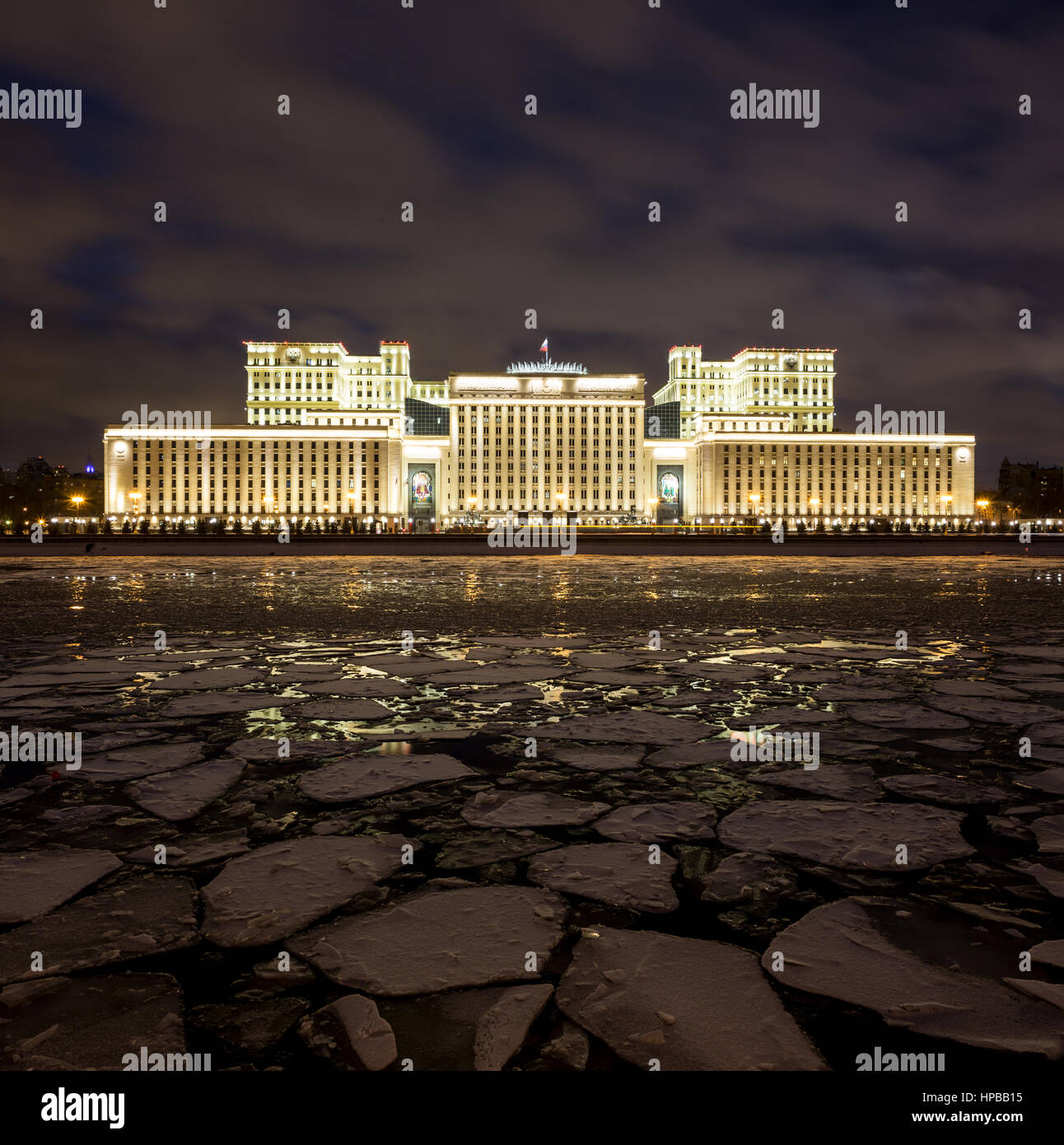 Ministero russo della difesa di sera in inverno su uno sfondo di cielo nuvoloso. Il primo piano è Mosca fiume coperta da ghiaccio floes. Foto Stock