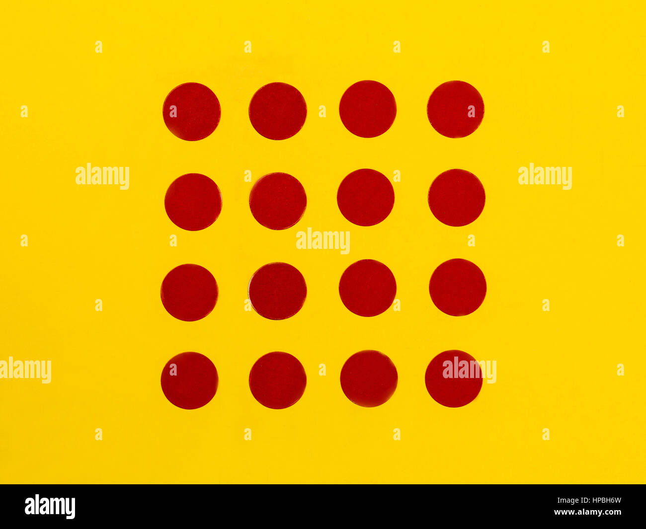 Puntini rossi su un brillante sfondo giallo con spazio di copia Foto Stock