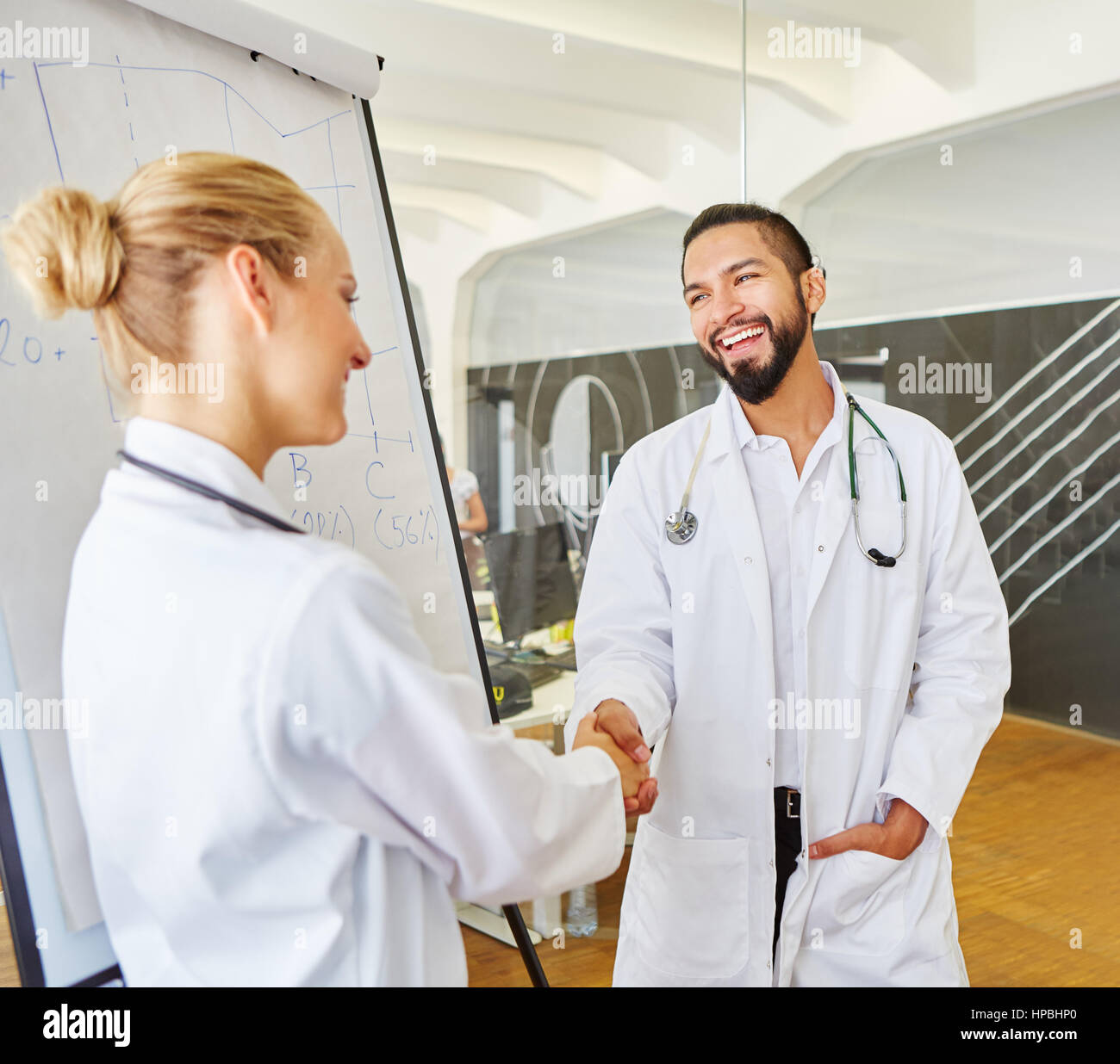 Stretta di mano tra medico e istruttore durante il seminario di medico Foto Stock