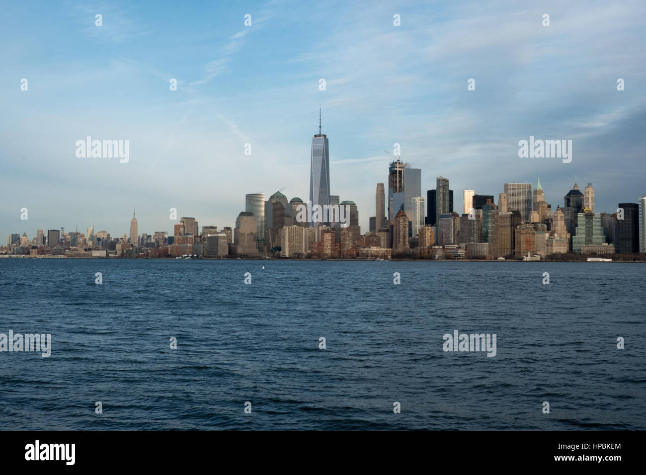 Famosa New York skyline della città e del porto di New York come si vede da una barca. Cielo blu e nuvole cirrus su New York del quartiere finanziario. Giornata di sole loo Foto Stock