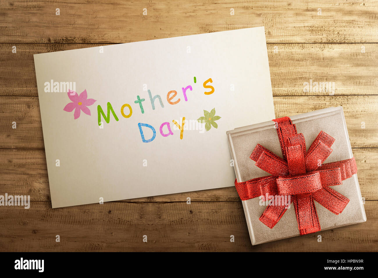 Scatola regalo bianca con la festa della mamma saluto su carta al di sopra del tavolo in legno Foto Stock