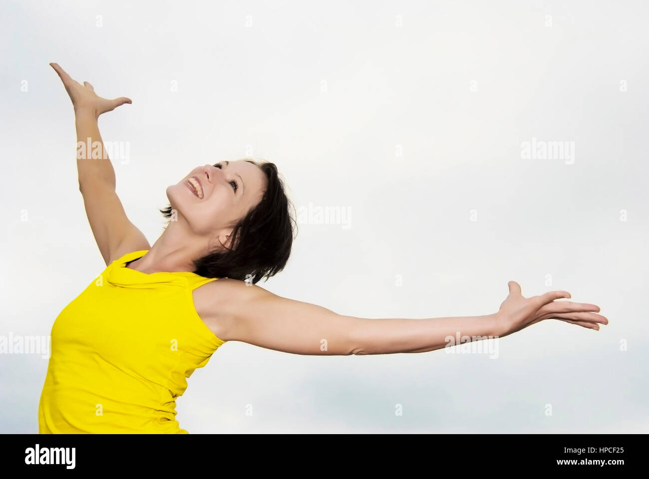 Lebensfrohe Frau streckt sich unter freiem Himmel - donna stretching sotto il cielo libero Foto Stock