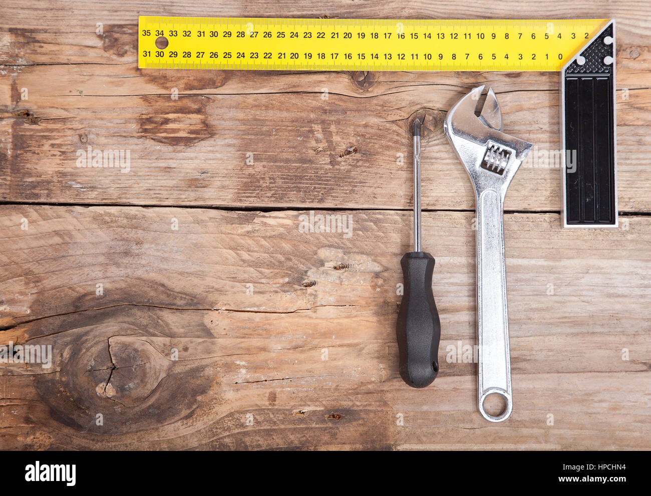 Square, il martello e cacciavite su sfondo di legno Foto Stock
