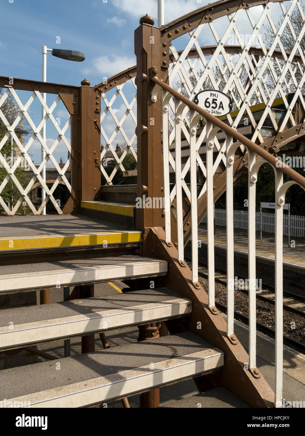 Ferro battuto pedonale passerella ferroviaria, Stamford stazione ferroviaria, Lincolnshire, England, Regno Unito Foto Stock