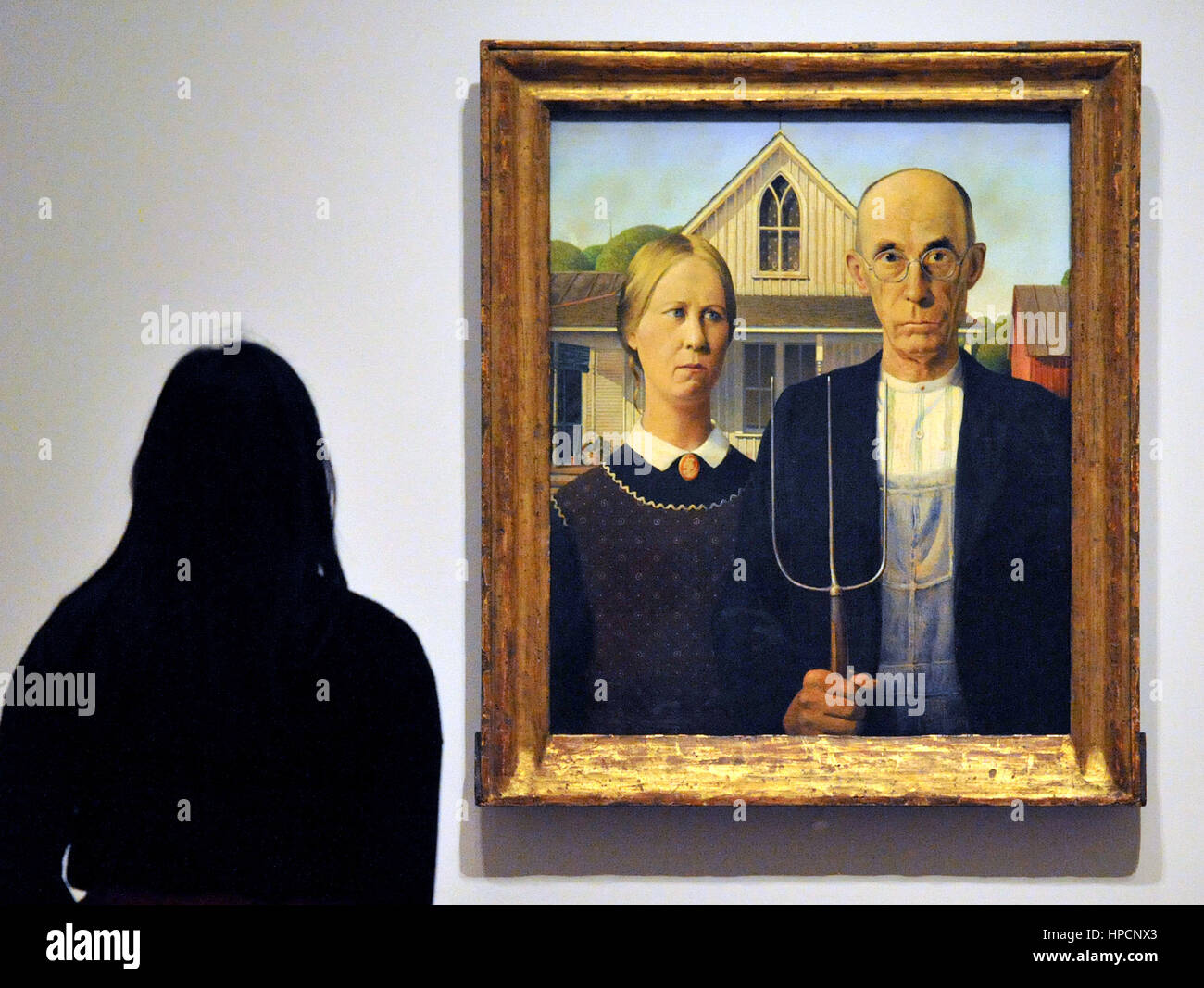 Una donna guarda al Gotico americano da concedere il legno sul display durante un photocall in gallerie Sackler presso la Royal Academy of Arts di Londra, davanti all'apertura del loro America dopo la caduta: Pittura negli anni trenta del novecento mostra. Foto Stock