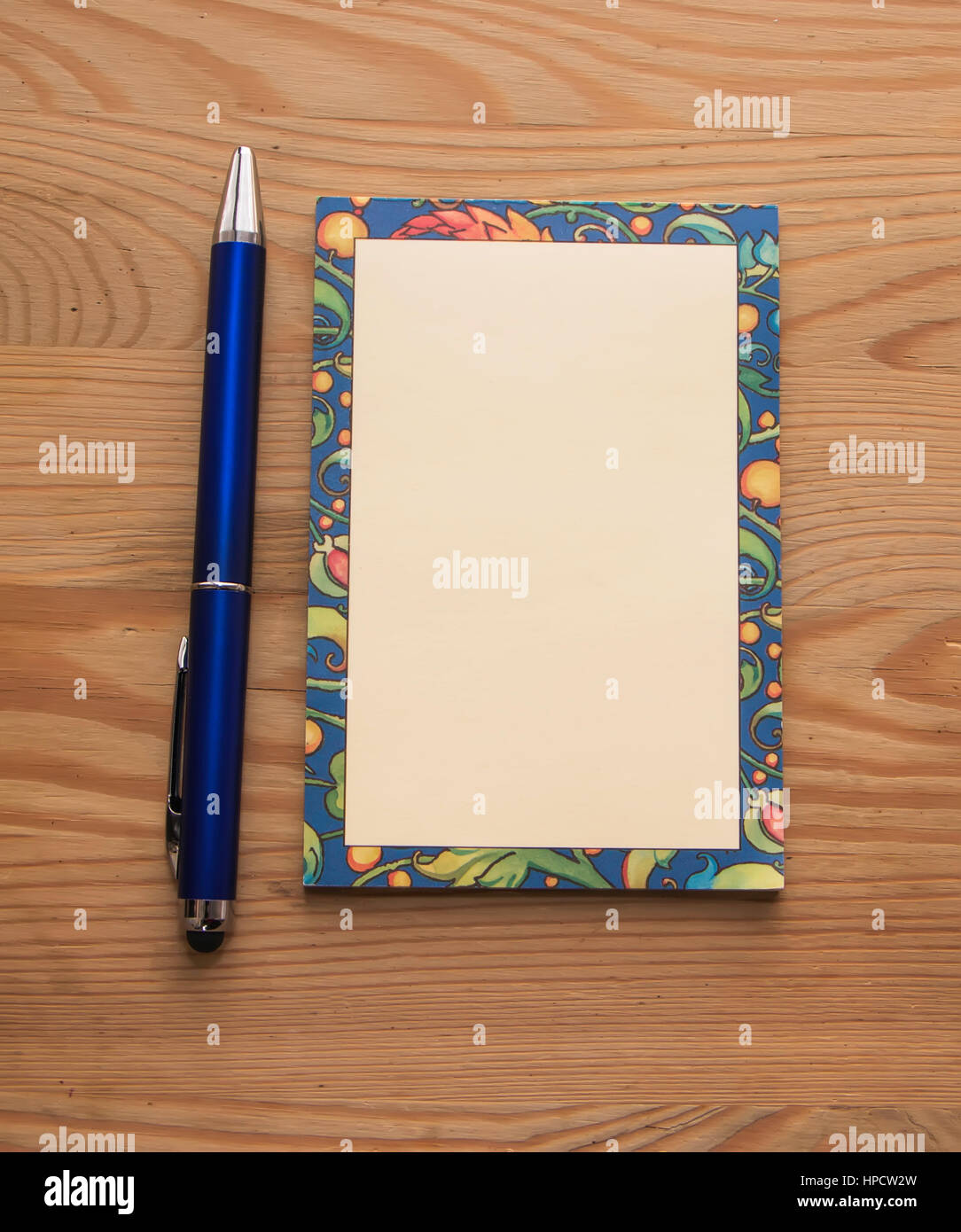 Blocco note colorate e una penna di colore blu su uno sfondo di legno Foto Stock