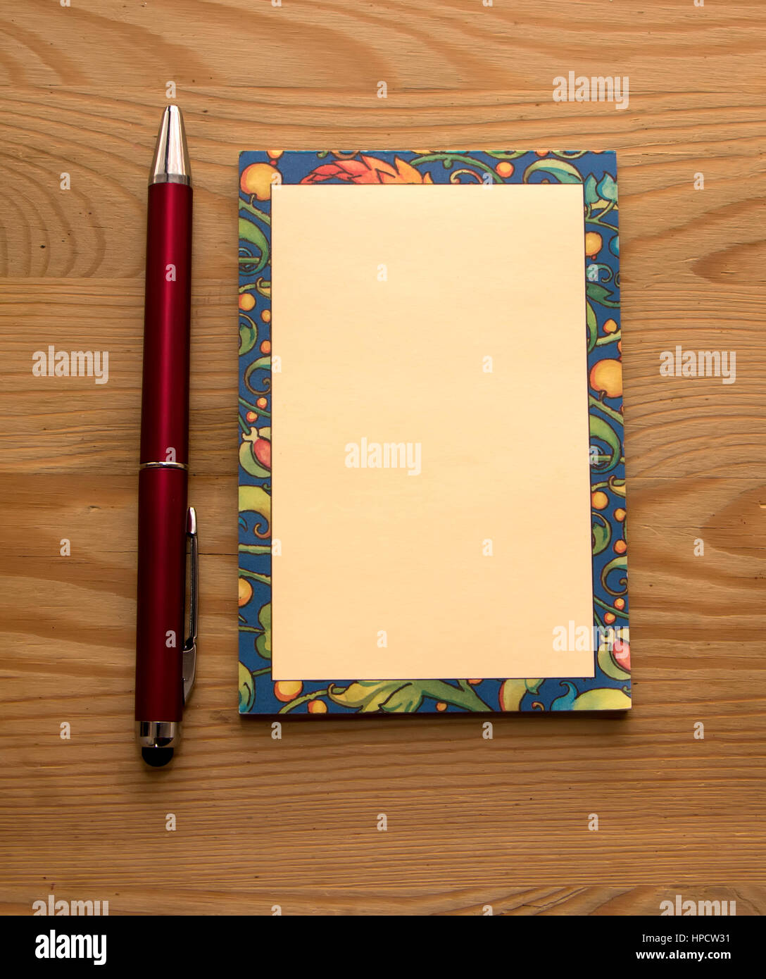 Blocco note colorate e ared penna su un sfondo di legno Foto Stock