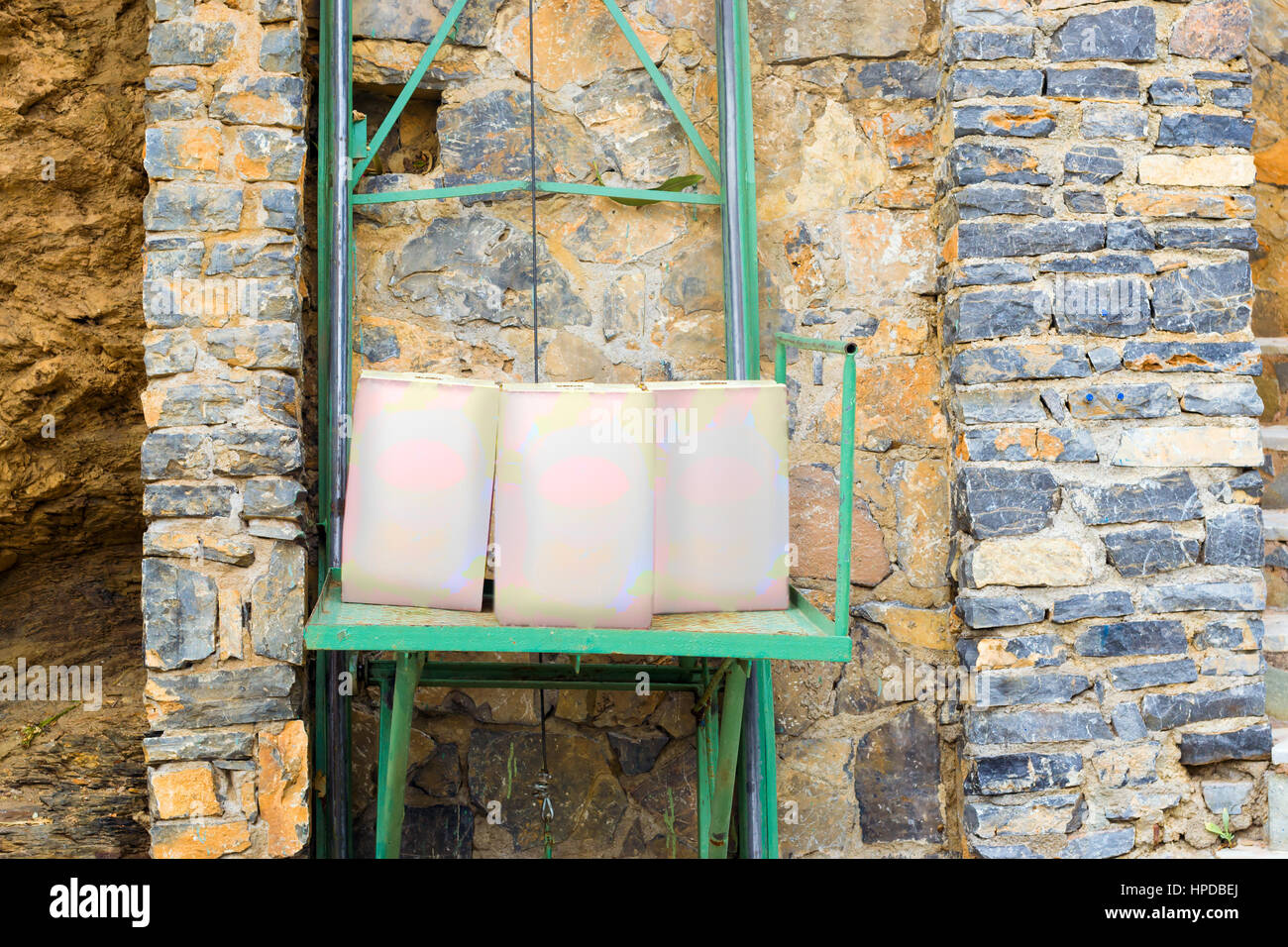 20 litri di vino scatola stand sulla miniatura ascensore per il sollevamento dei prodotti dalla strada al ristorante. Compatta costruzione meccanica per abbassare i carichi leggeri Foto Stock