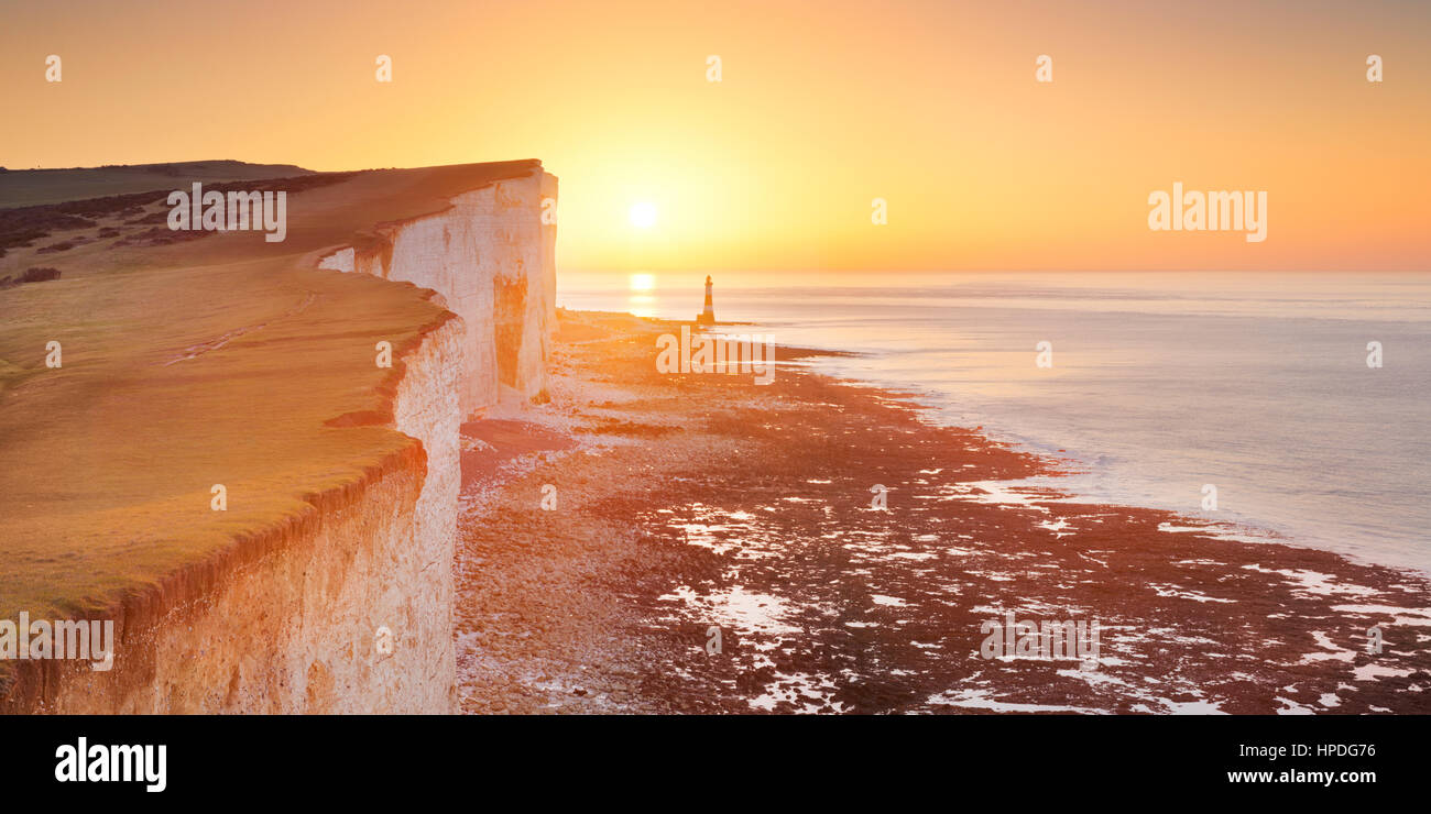 Sunrise oltre le scogliere e faro di Beachy Head sulla costa sud dell'Inghilterra. Foto Stock