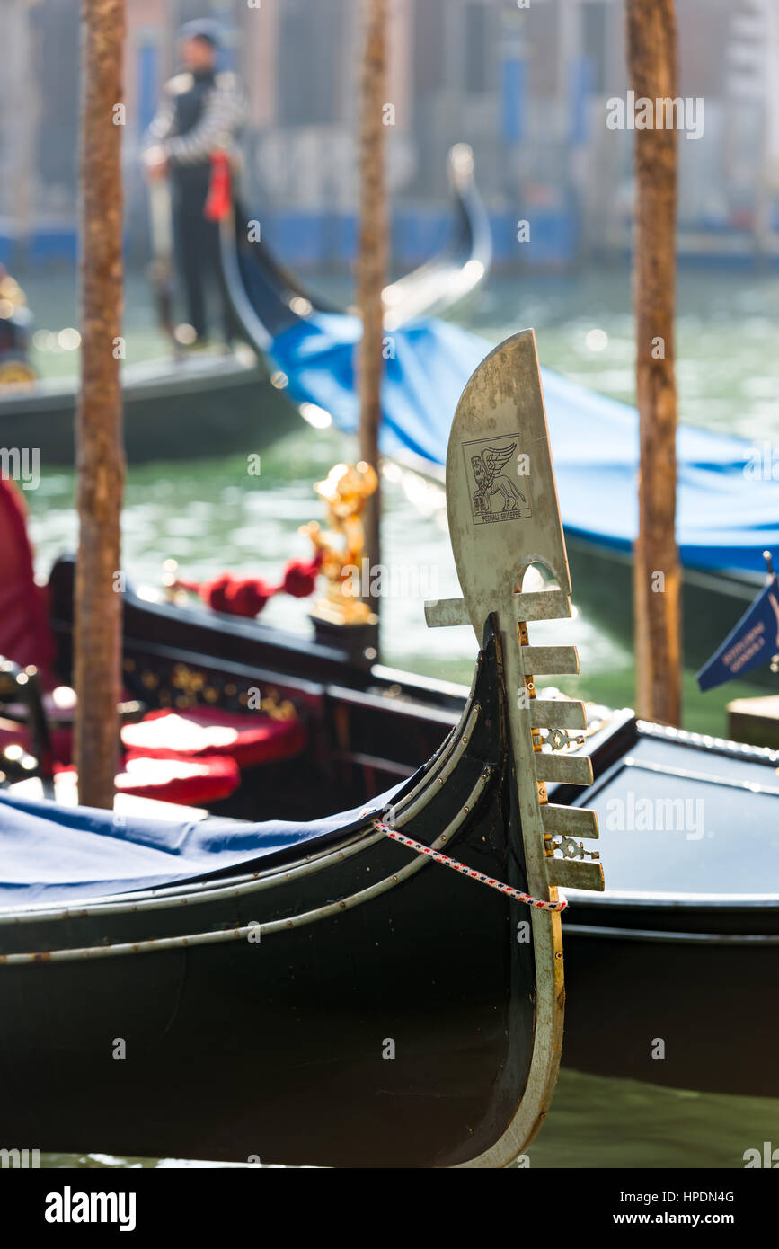 un gondoliere è visto in piedi in una silhouette sfocata con l'iconica gonna in gondola mostrata in dettaglio in primo piano Foto Stock