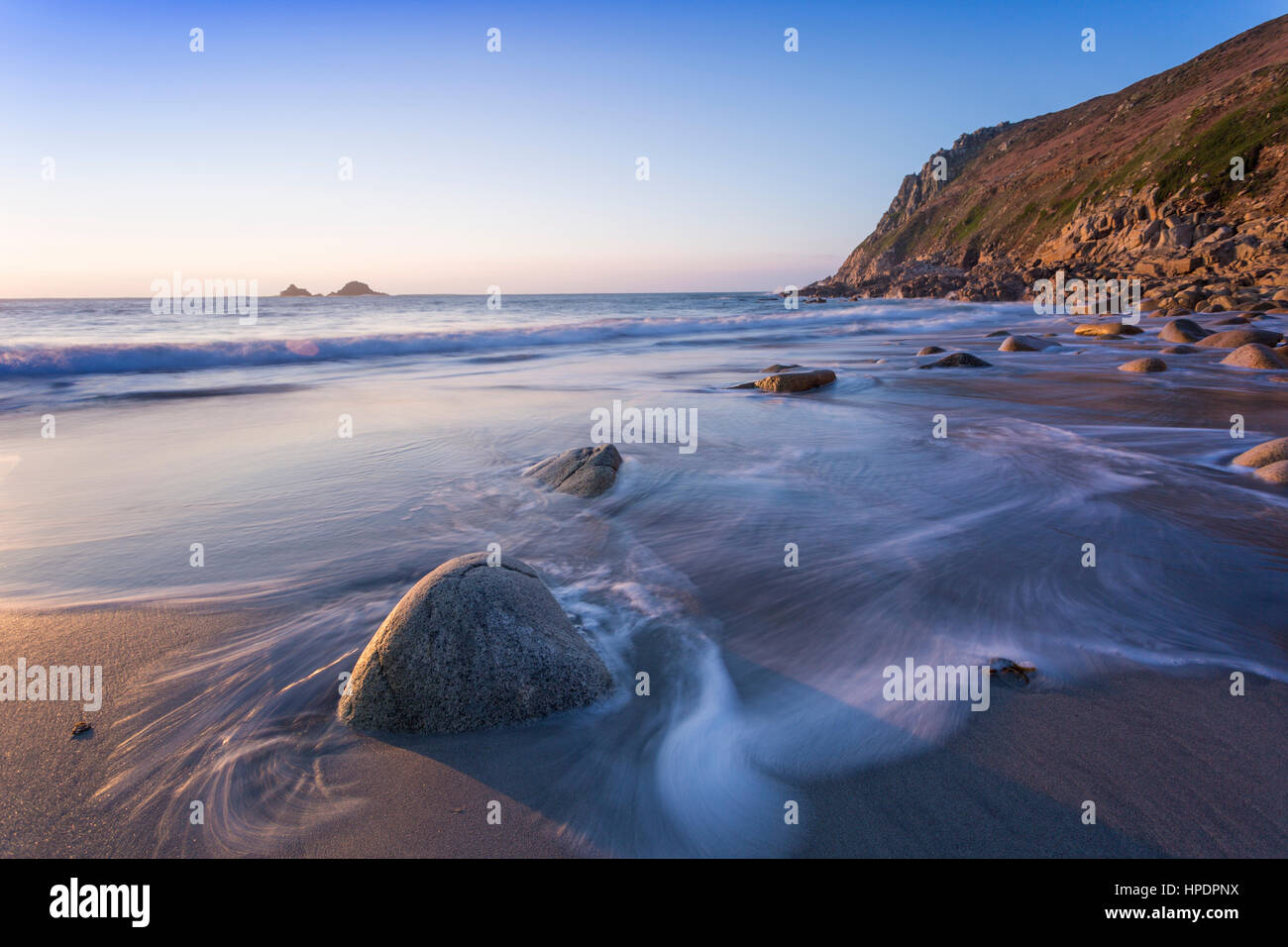 Una lunga esposizione di Porth Nanven, uova di dinosauro beach, con le off shore isole chiamato Brisons nella distanza a West Cornwall, nei pressi di San Giusto Foto Stock