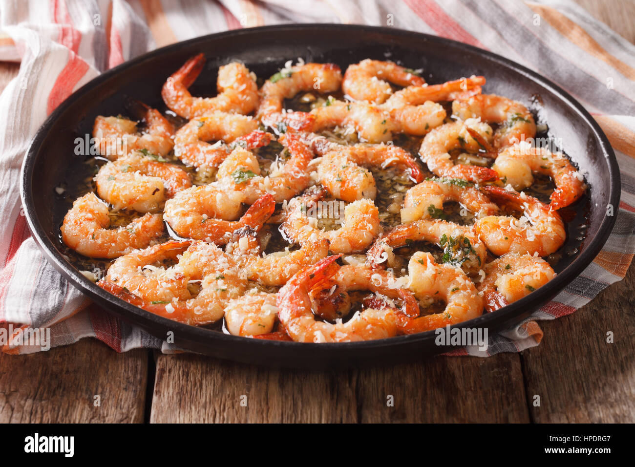 Cibo saporito: gamberi in salsa di aglio con formaggio parmigiano e le erbe closeup sul tavolo orizzontale. Foto Stock