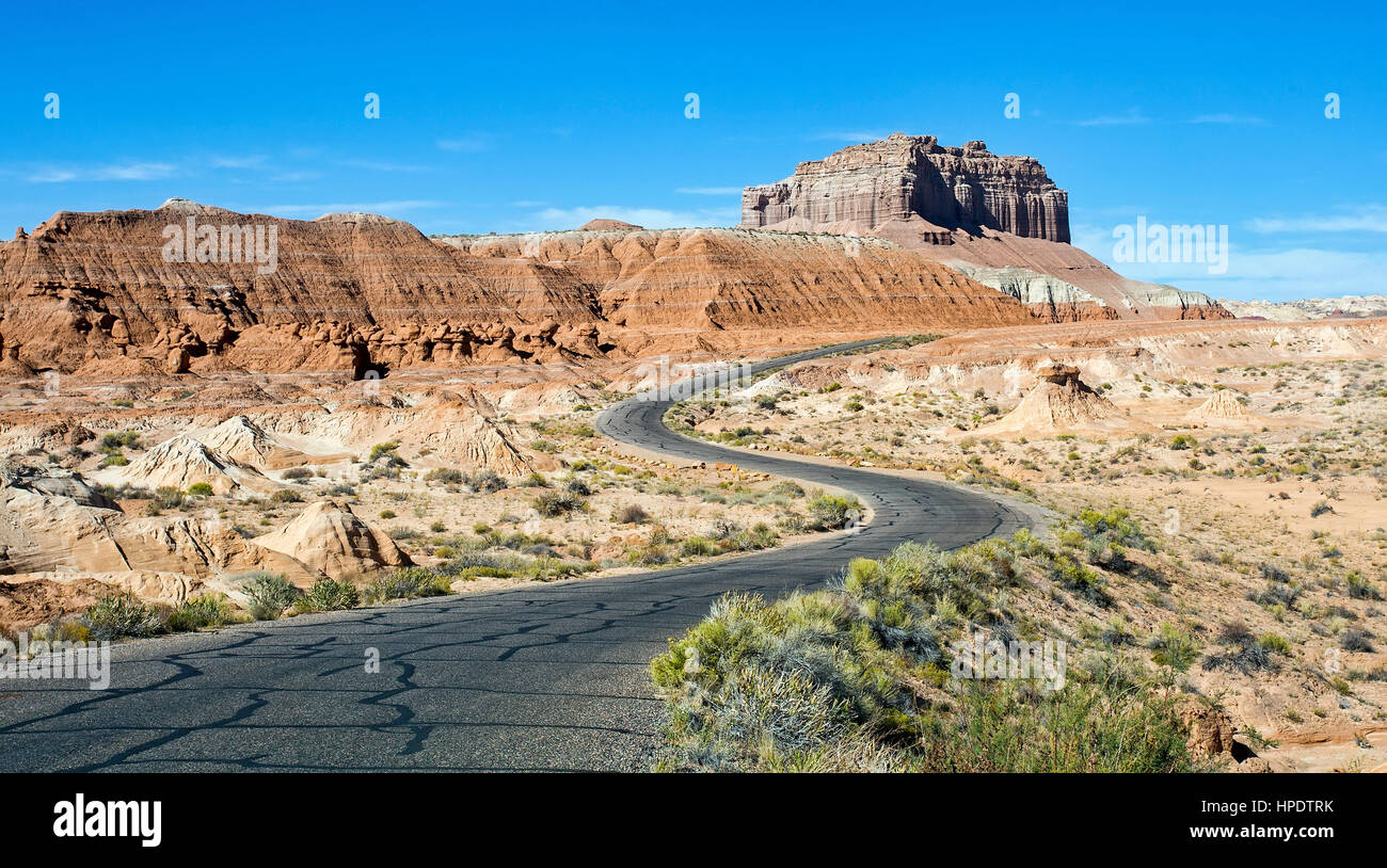 Una semplice strada asfaltata si snoda attraverso un deserto roccioso paesaggio. Foto Stock