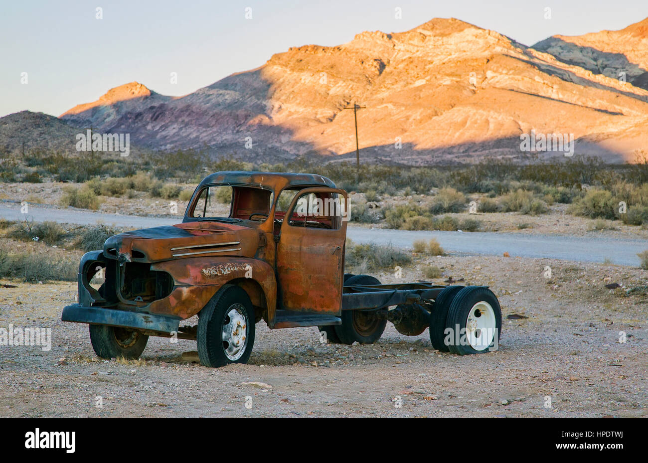 Un vecchio arrugginito carrello si trova abbandonato in un paesaggio desertico. Foto Stock