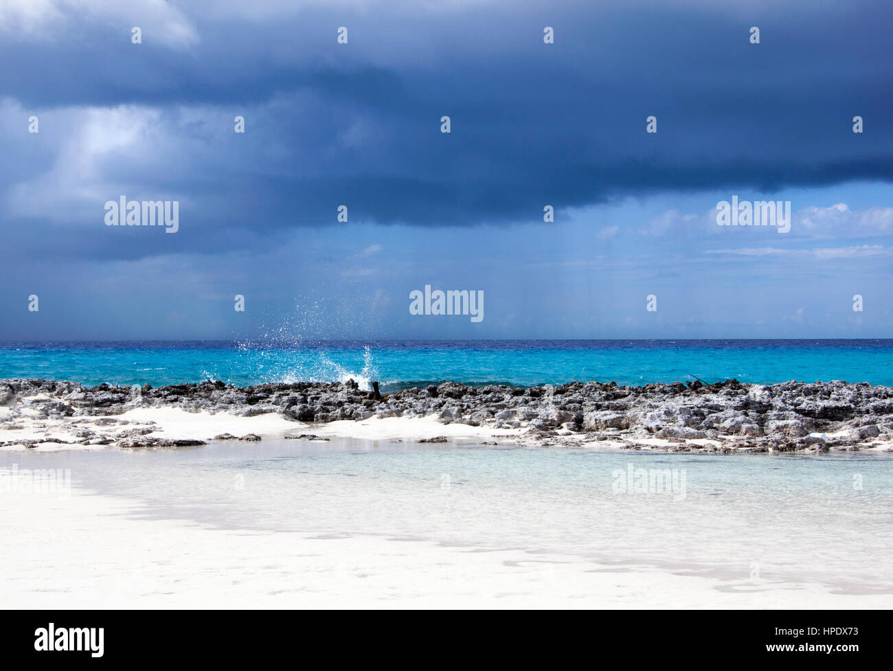 Il dark cloud con una pioggia è venuta verso isola disabitata di Half Moon Cay (Bahamas). Foto Stock